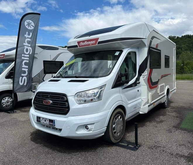 Camping-car Challenger exposé sur un parking avec bannière Sunlight en arrière-plan.