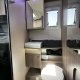 Salle de bain moderne dans un camping-car avec toilettes et lavabo intégrés.