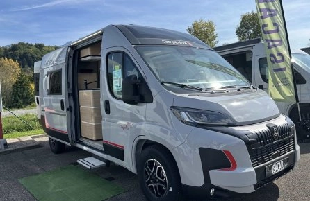 Fourgon aménagé Camperêve garé sur un parking, porte latérale ouverte