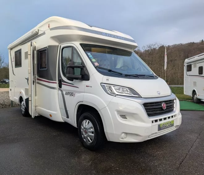 Camping-car Rapido blanc stationné sur un parking extérieur