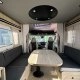 Intérieur spacieux d'un camping-car moderne avec table et banquettes grises