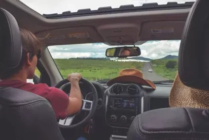 Conducteur sur route de campagne avec vue dégagée par le toit ouvrant