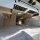 Intérieur d'un van aménagé avec lit et rangements en bois clair