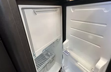 Réfrigérateur ouvert avec étagères et bacs de rangement visibles