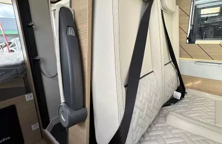 Siège de camping-car avec ceinture de sécurité et revêtement en cuir beige.