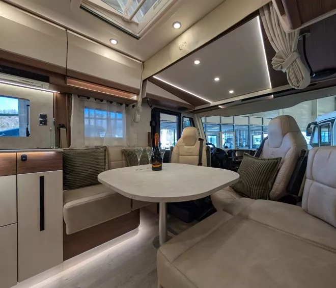 Intérieur spacieux d'un camping-car moderne avec table et sièges en cuir beige