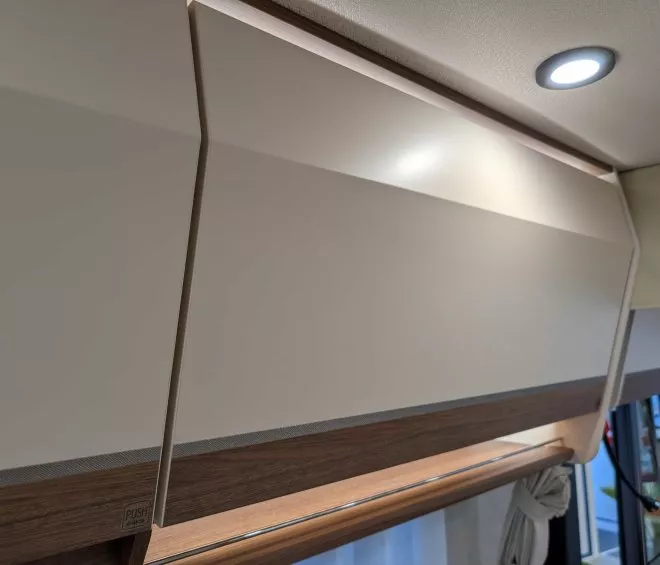 Placard de rangement moderne avec éclairage intégré dans un intérieur de véhicule récréatif.