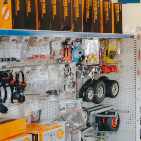 Rayon de quincaillerie avec outils et roues exposés sur étagères