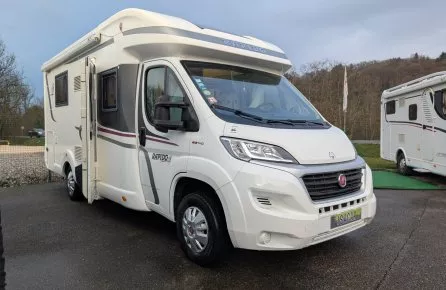 Camping-car Rapido blanc stationné sur un parking extérieur