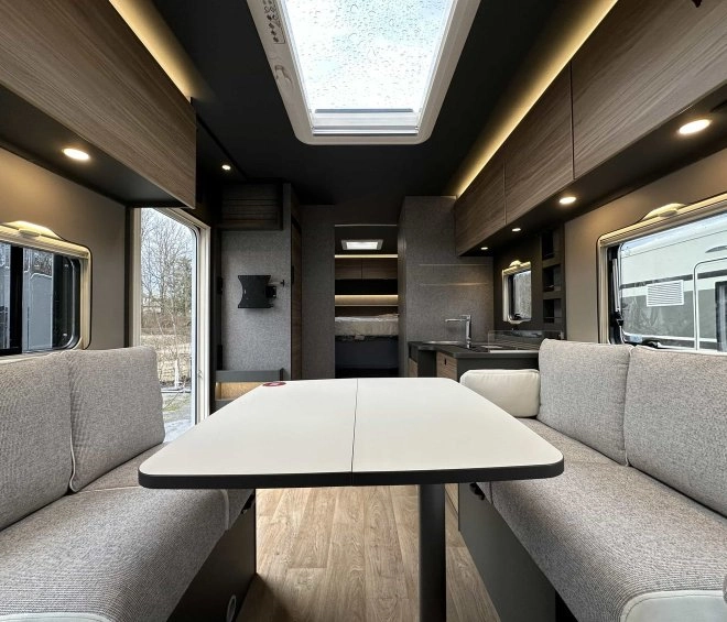 Intérieur moderne d'un camping-car avec table et banquettes grises