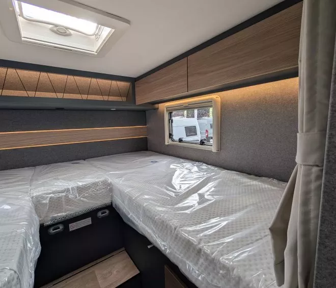 Intérieur d'une caravane avec lits jumeaux et rangement en bois