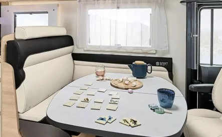 Intérieur d'un camping-car avec table dressée pour le thé et jeu de société.