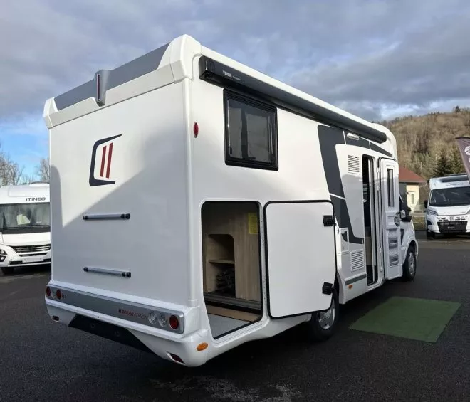 Camping-car blanc stationné sur un parking avec ciel nuageux en arrière-plan