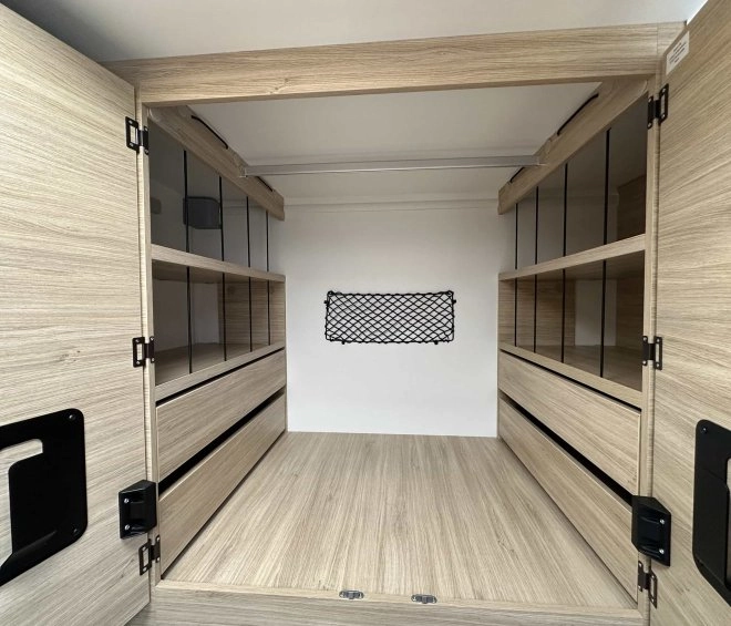 Intérieur d'un placard en bois clair avec étagères et filet de rangement