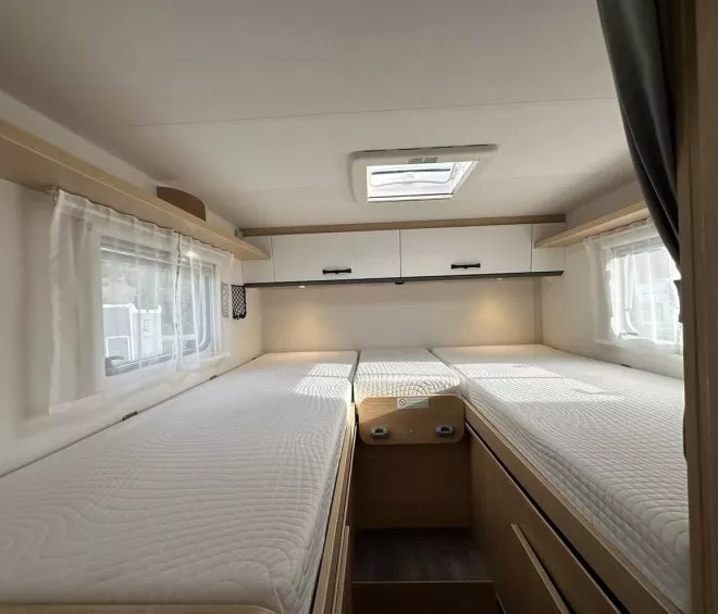 Intérieur d'une caravane avec deux lits simples et rangements