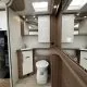 Salle de bain moderne dans un camping-car avec toilettes et lavabo intégrés.