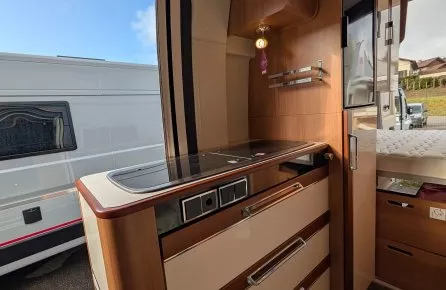 Intérieur d'un camping-car avec cuisine équipée et rangements en bois