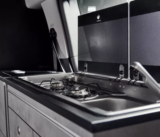 Cuisine intégrée dans un van avec plaques de cuisson et évier en acier inoxydable