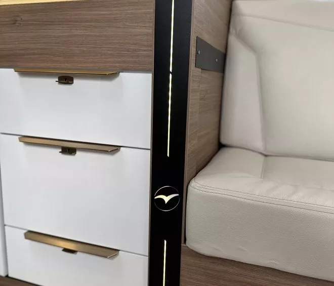Intérieur de camping-car avec tiroirs en bois et siège beige
