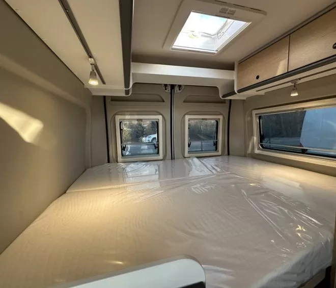 Intérieur d'un camping-car avec lit double et éclairage naturel