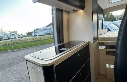 Intérieur moderne d'un camping-car avec cuisine équipée et rangements.