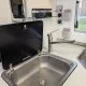 Évier en acier inoxydable avec robinet moderne dans une cuisine compacte de camping-car.