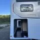 Compartiment de rangement ouvert d'un camping-car Globebus GT sur un parking.