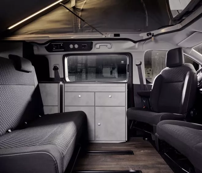Intérieur d'un van aménagé avec sièges et rangements modernes