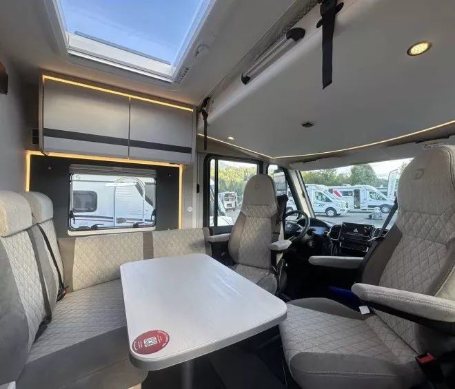 Intérieur d'un camping-car moderne avec sièges et table, éclairage LED