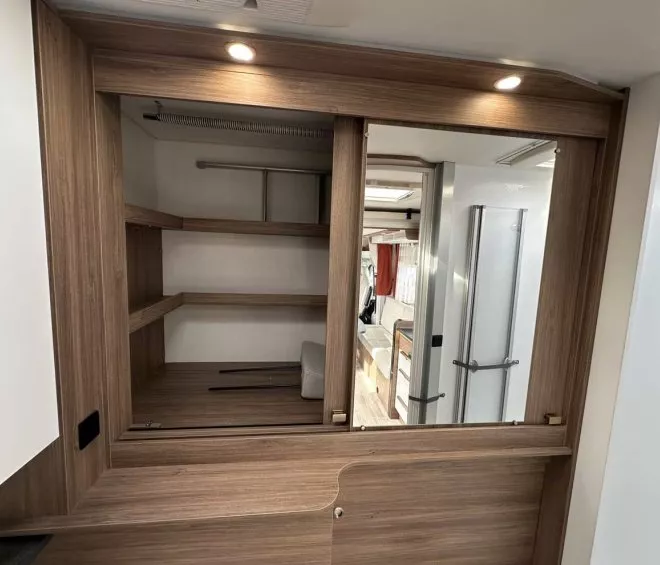 Intérieur d'un camping-car avec placard en bois et douche visible