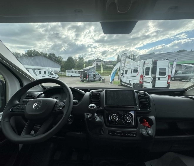 Vue intérieure d'un camping-car avec exposition de véhicules en arrière-plan