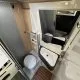 Salle de bain compacte dans un camping-car moderne avec lavabo et toilettes.
