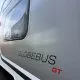 Vue latérale d'un camping-car Globebus GT avec fenêtre et logo visibles