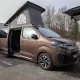 Van aménagé avec toit relevable sur un parking, modèle Crosscamp.