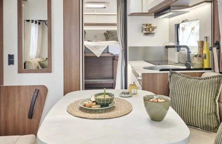 Intérieur moderne de camping-car avec cuisine et coin repas.