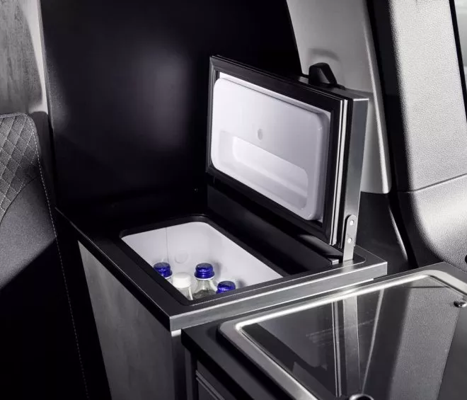 Mini-réfrigérateur ouvert dans un véhicule avec bouteilles d'eau à l'intérieur