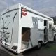 Camping-car Pilote stationné avec porte ouverte et porte-vélos à l'arrière.