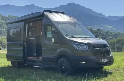 Véhicule utilitaire Ford aménagé en camping-car sur fond de montagnes