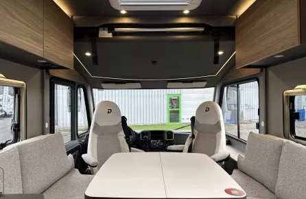 Intérieur d'un camping-car moderne avec table et sièges en tissu gris