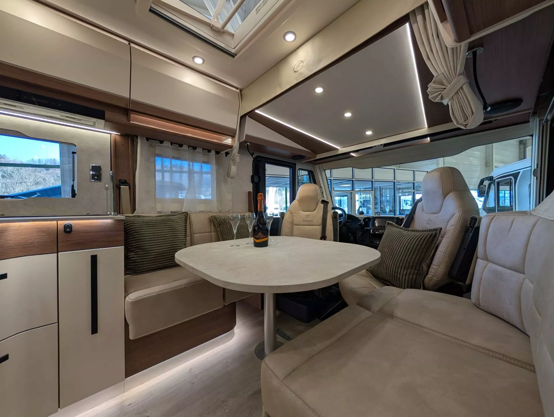 Intérieur spacieux d'un camping-car moderne avec table et sièges en cuir beige