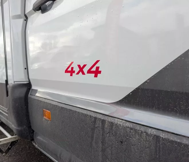 Flanc d'un véhicule 4x4 blanc avec marchepied visible