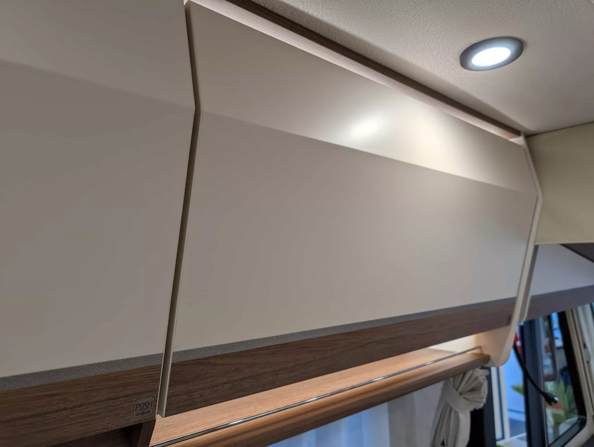 Placard de rangement moderne avec éclairage intégré dans un intérieur de véhicule récréatif.