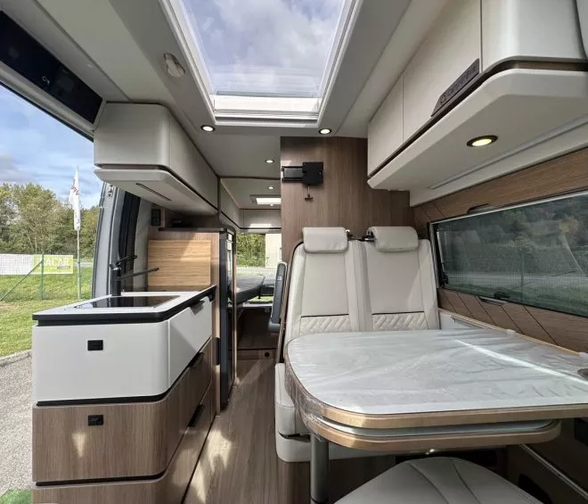 Intérieur moderne d'un camping-car avec cuisine et coin repas lumineux