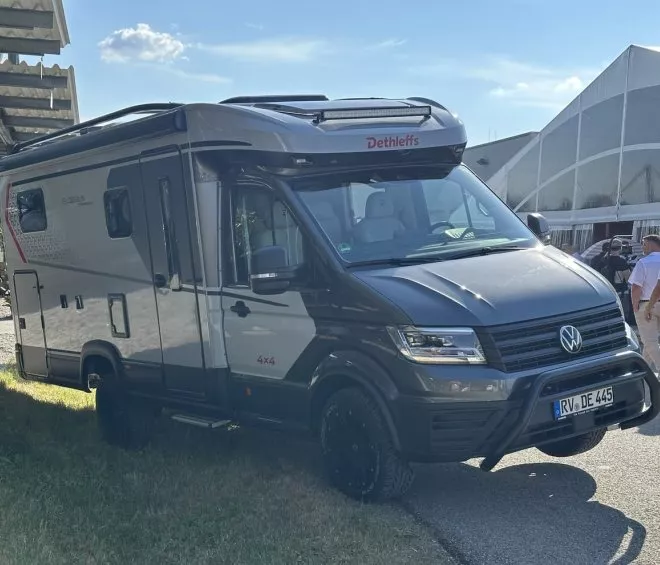 Camping-car Dethleffs Globebus 4x4 stationné en extérieur, avec des personnes en arrière-plan.