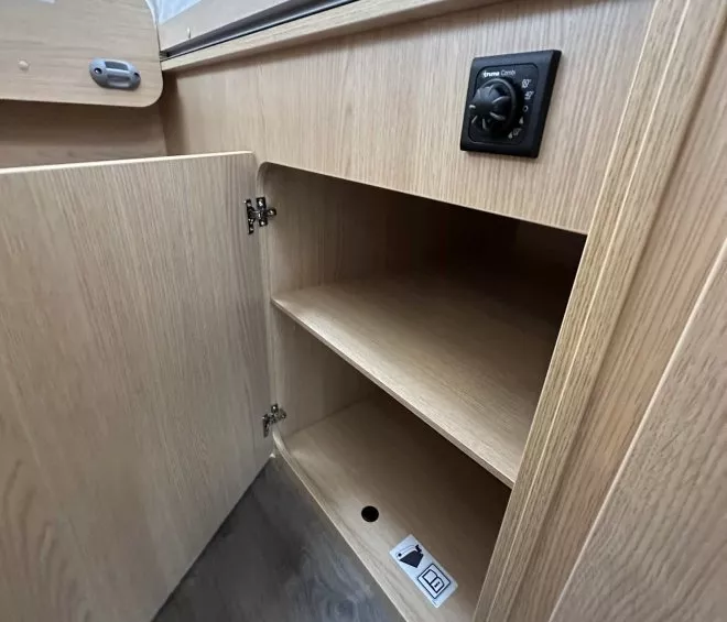 Placard en bois clair avec étagères et panneau de contrôle intégré