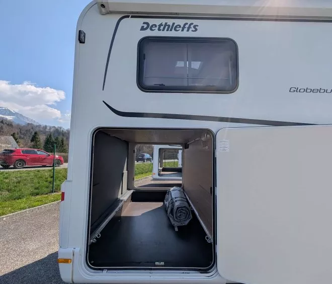 Compartiment de rangement ouvert d'un camping-car Dethleffs sous ciel ensoleillé