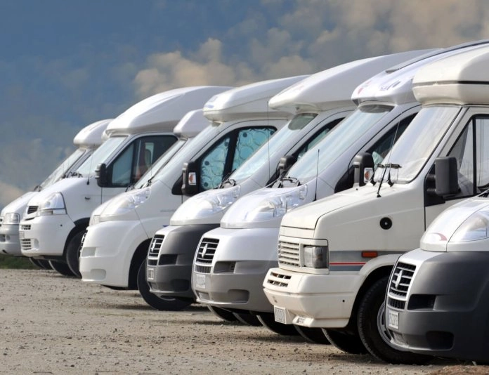 Alignement de camping-cars stationnés sur un terrain en plein air