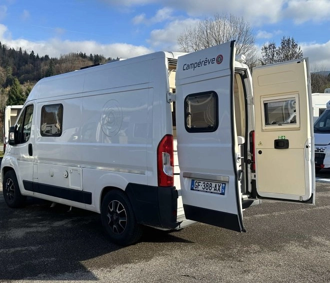 Fourgon aménagé Campérêve stationné en extérieur, portes arrière ouvertes