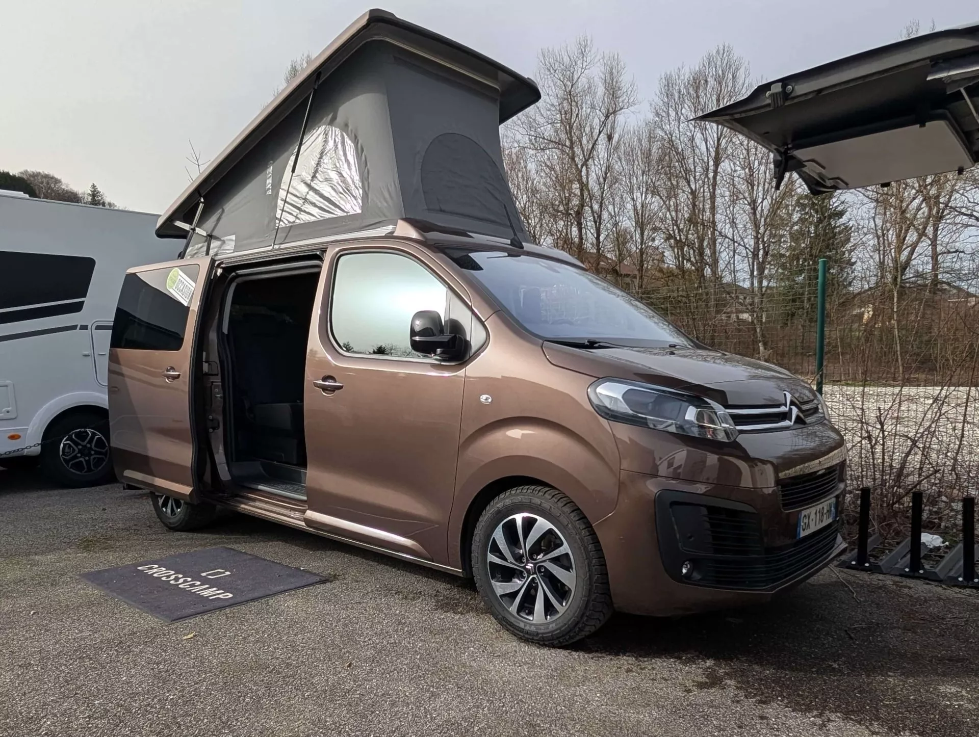 Van aménagé avec toit relevable sur un parking, modèle Crosscamp.