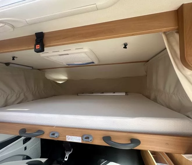 Lit escamotable dans un camping-car moderne avec rangement en bois